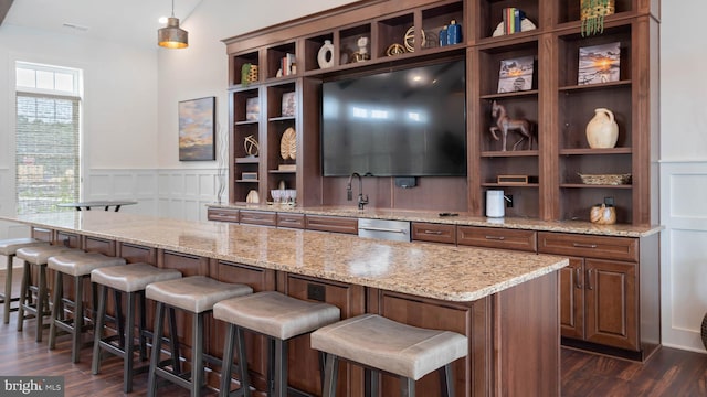 bar with light stone countertops, sink, hanging light fixtures, dark hardwood / wood-style floors, and stainless steel dishwasher