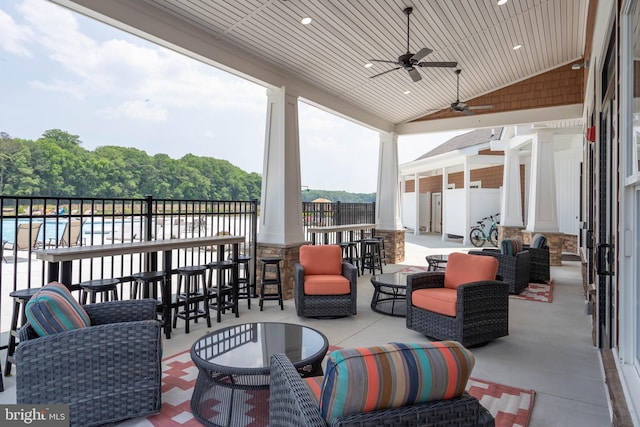 view of patio with outdoor lounge area, ceiling fan, and a bar