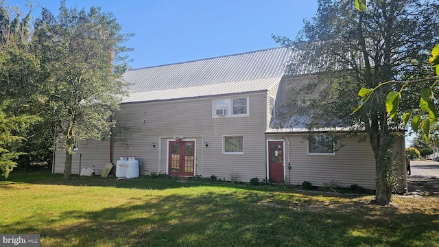 rear view of house featuring a lawn