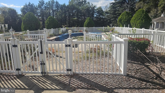 view of gate featuring a covered pool