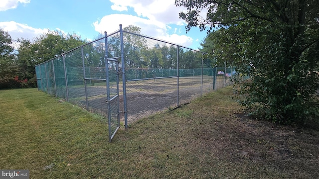 view of sport court with a lawn