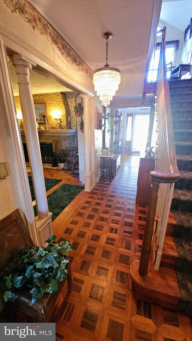 hall with decorative columns and a chandelier