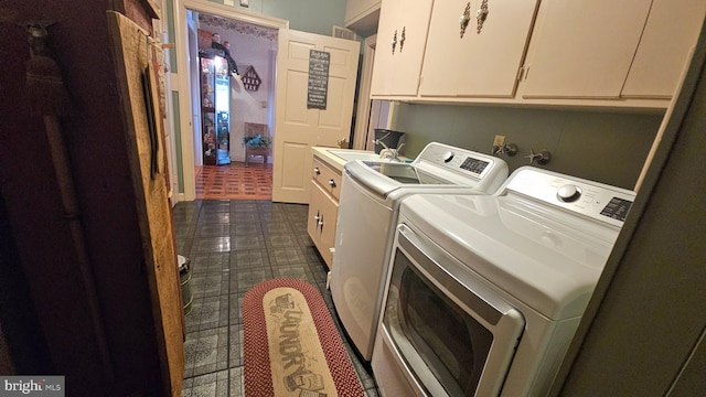 clothes washing area featuring sink, washer and dryer, and cabinets