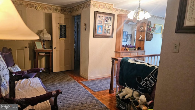 hall with ornamental molding, an inviting chandelier, and dark parquet flooring