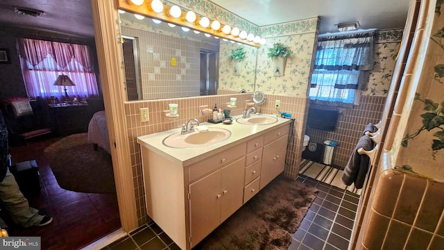 bathroom with vanity, an enclosed shower, tile patterned floors, and tile walls