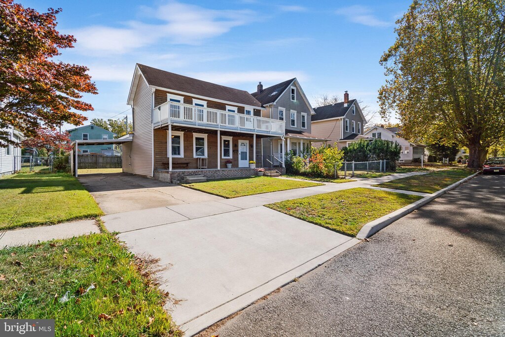 view of front of home featuring a front lawn, a porch, and a balcony