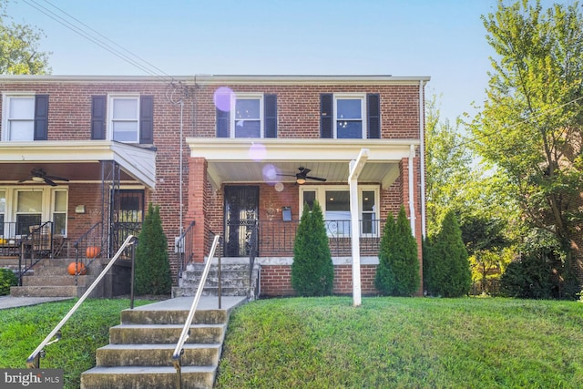 view of property featuring ceiling fan, a front yard, and a porch