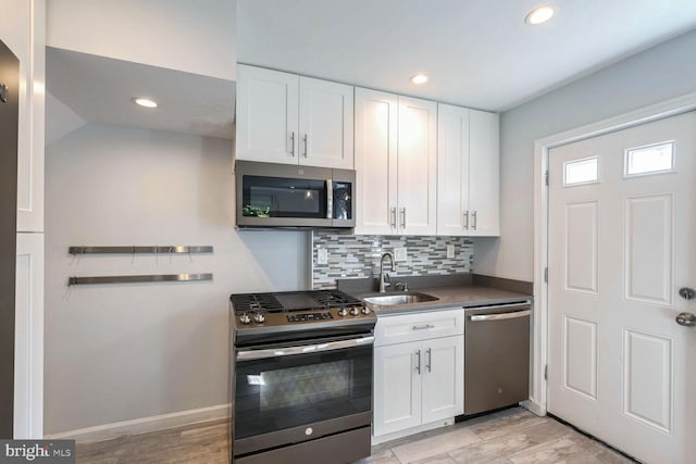 kitchen featuring white cabinets, light hardwood / wood-style floors, stainless steel appliances, and sink