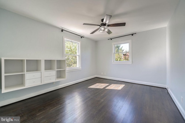 unfurnished room with ceiling fan and dark wood-type flooring