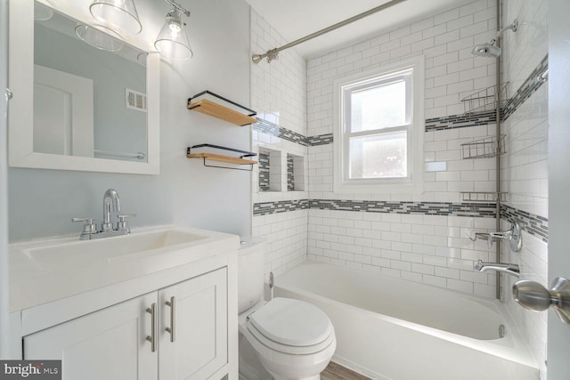 full bathroom with vanity, toilet, and tiled shower / bath combo