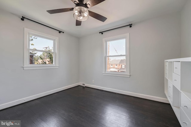 unfurnished room with dark wood-type flooring and ceiling fan