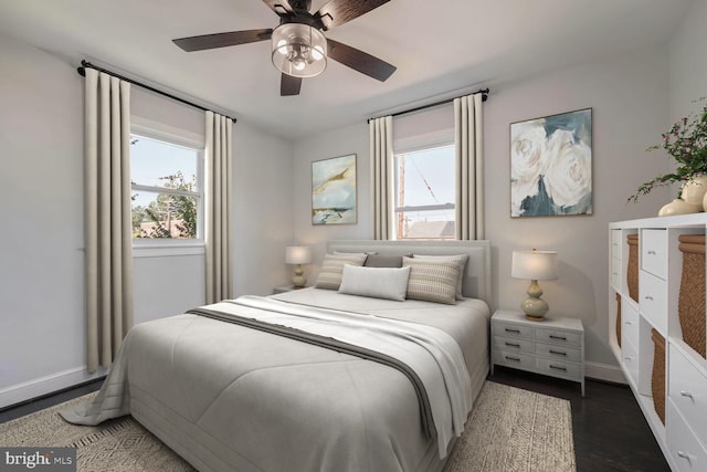 bedroom featuring ceiling fan, dark hardwood / wood-style flooring, and multiple windows