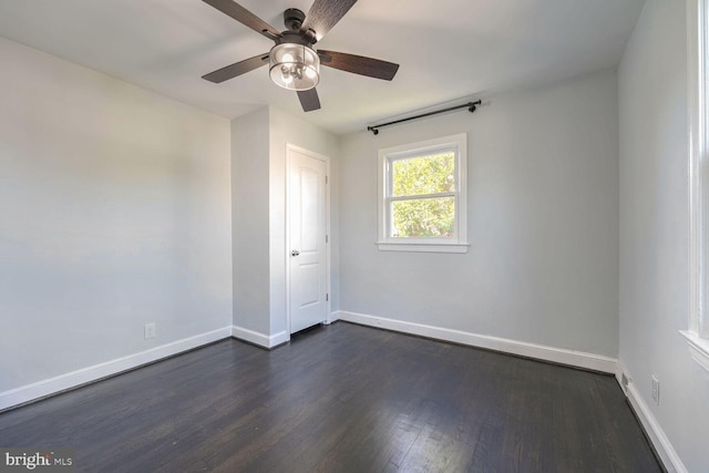 spare room with ceiling fan and dark hardwood / wood-style flooring