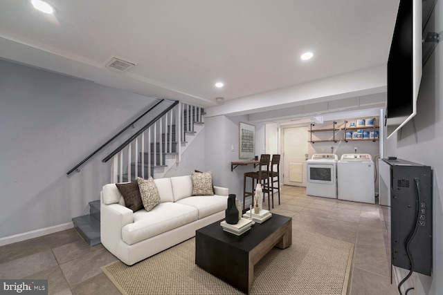 living room with washing machine and clothes dryer and tile patterned flooring