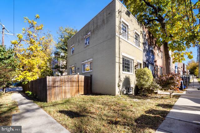 view of side of home with fence and stucco siding