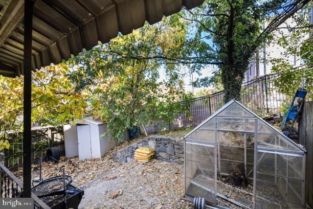 fenced backyard with an outbuilding and an exterior structure