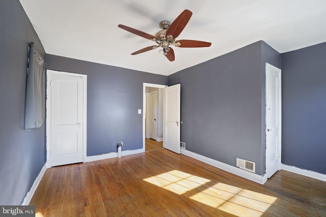 unfurnished bedroom with baseboards, wood finished floors, and ceiling fan