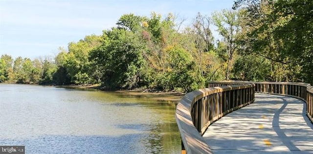 dock area with a water view and a wooded view