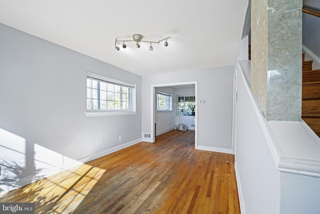foyer featuring hardwood / wood-style flooring, stairs, and baseboards