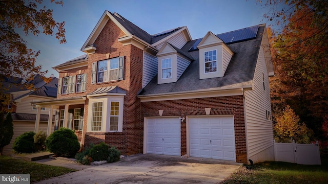 view of front of property featuring solar panels and a garage