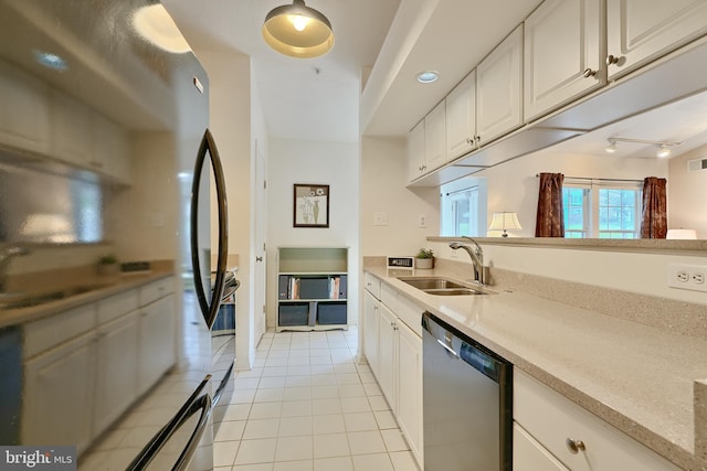 kitchen featuring sink, refrigerator, light tile patterned flooring, stainless steel dishwasher, and white cabinets