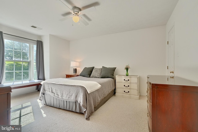 bedroom featuring visible vents, a ceiling fan, and light colored carpet