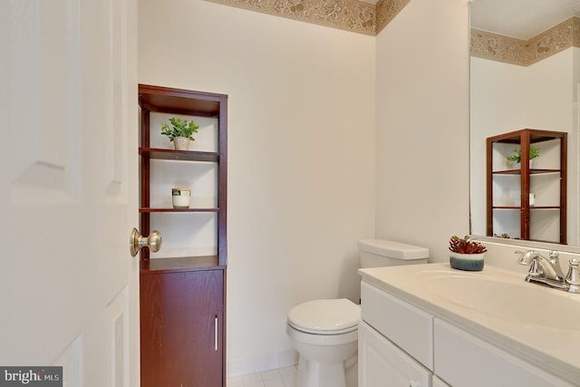 bathroom with toilet, vanity, and tile patterned flooring