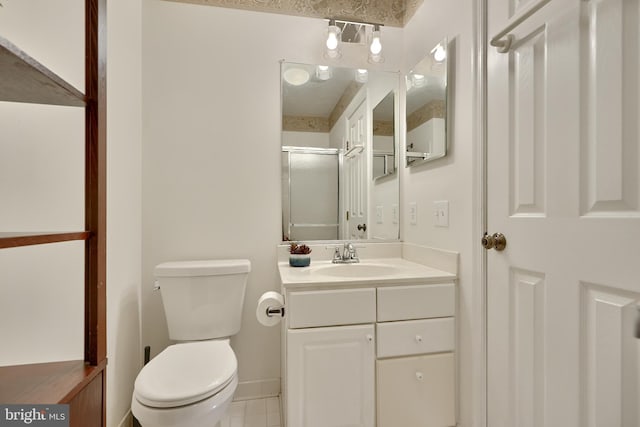 bathroom with vanity, tile patterned flooring, a shower with shower door, and toilet