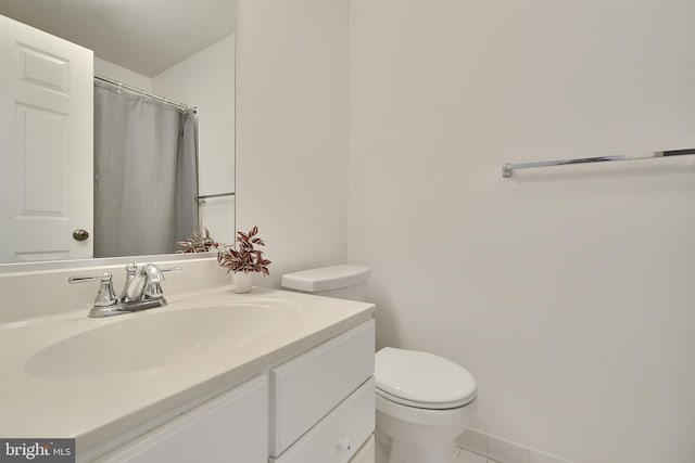full bath featuring toilet, vanity, and tile patterned floors
