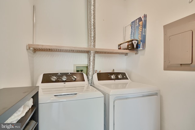 clothes washing area with electric panel, washer and dryer, and laundry area