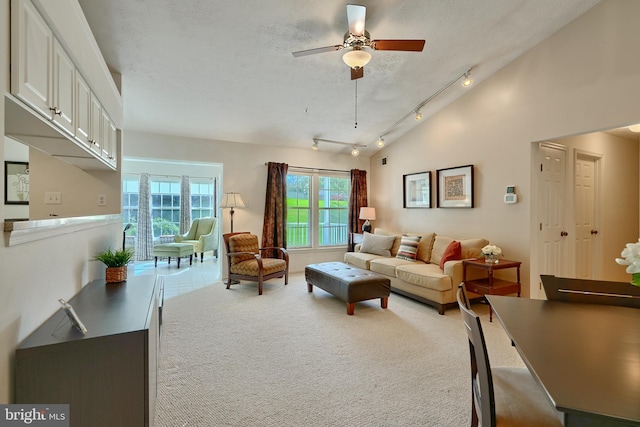 living room featuring track lighting, a textured ceiling, carpet floors, and ceiling fan