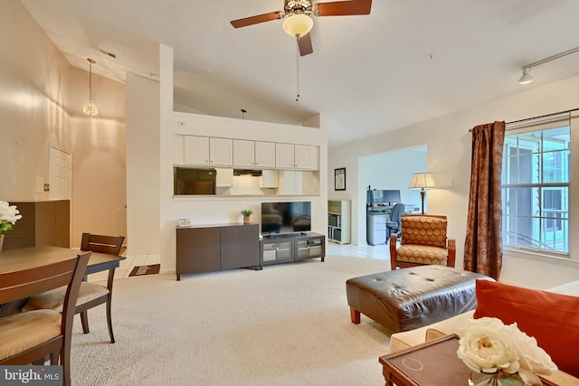 carpeted living room featuring rail lighting, ceiling fan, and high vaulted ceiling