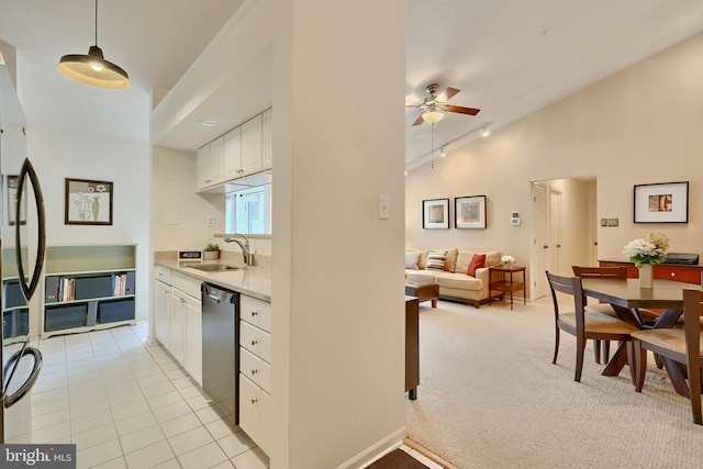 kitchen with appliances with stainless steel finishes, white cabinetry, sink, light colored carpet, and decorative light fixtures