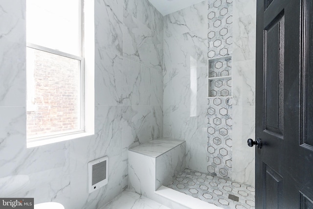 bathroom with a tile shower and heating unit