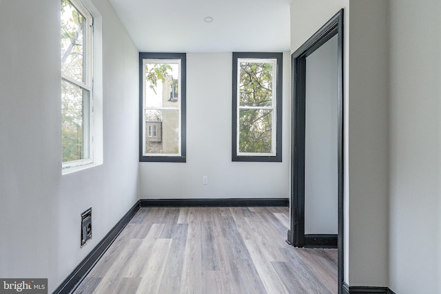 unfurnished room featuring plenty of natural light and light hardwood / wood-style flooring