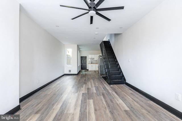 unfurnished living room with hardwood / wood-style floors and ceiling fan