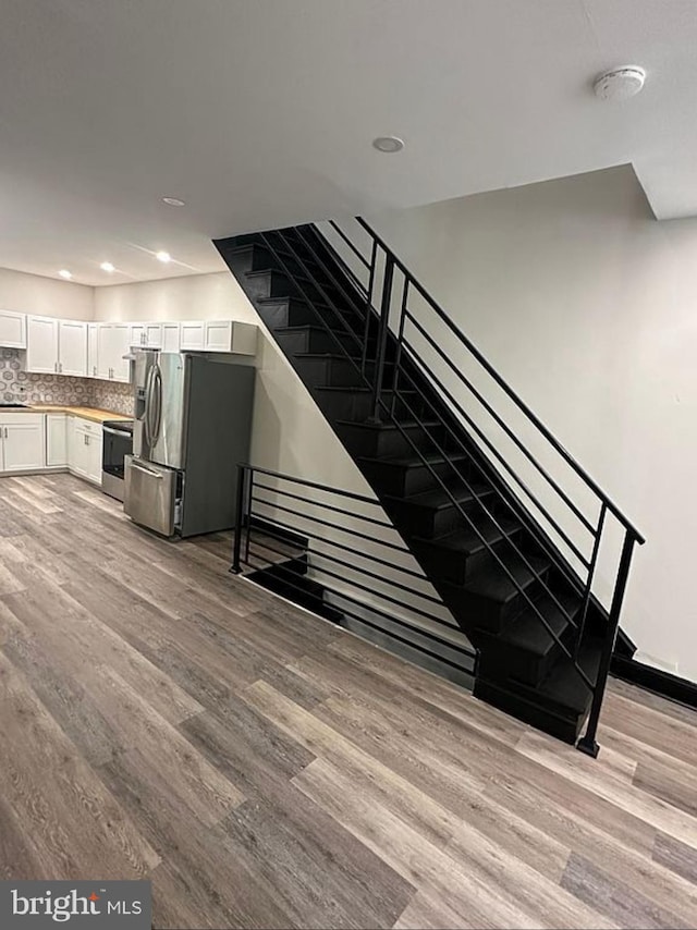 staircase with hardwood / wood-style floors