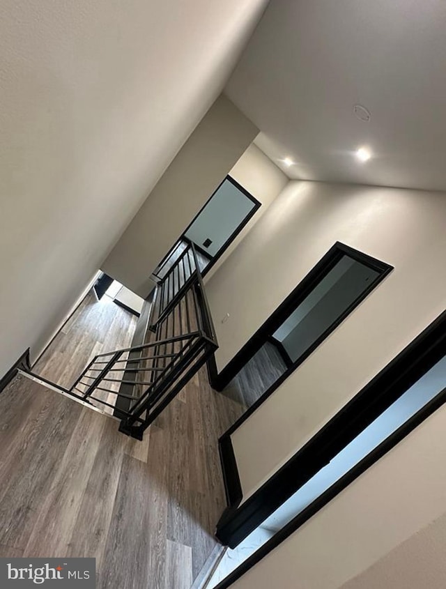 stairway featuring hardwood / wood-style flooring and vaulted ceiling