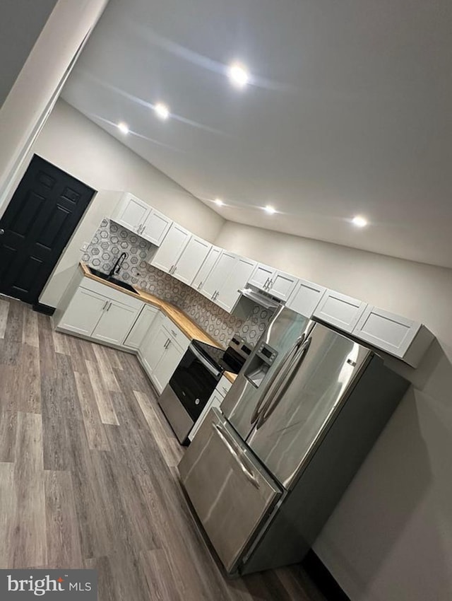 kitchen featuring lofted ceiling, backsplash, white cabinets, sink, and dark hardwood / wood-style flooring