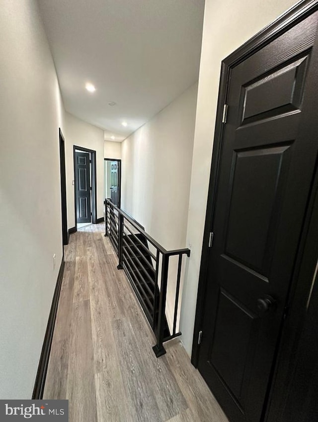 hallway with light hardwood / wood-style floors