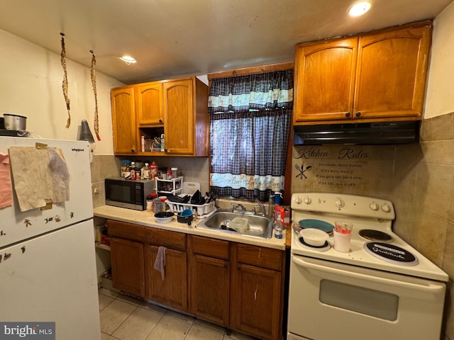 kitchen featuring white appliances, backsplash, light tile patterned floors, and sink