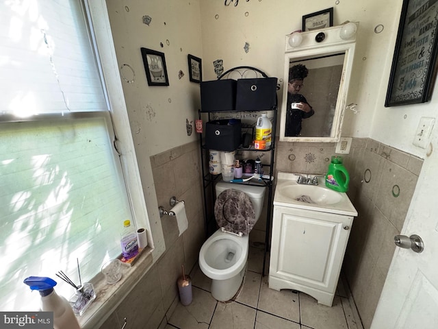 bathroom featuring vanity, toilet, tile walls, and tile patterned flooring