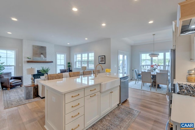 kitchen with stainless steel appliances, decorative light fixtures, and a healthy amount of sunlight