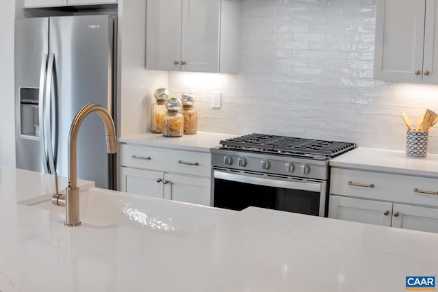 kitchen featuring sink, backsplash, stainless steel appliances, and white cabinets