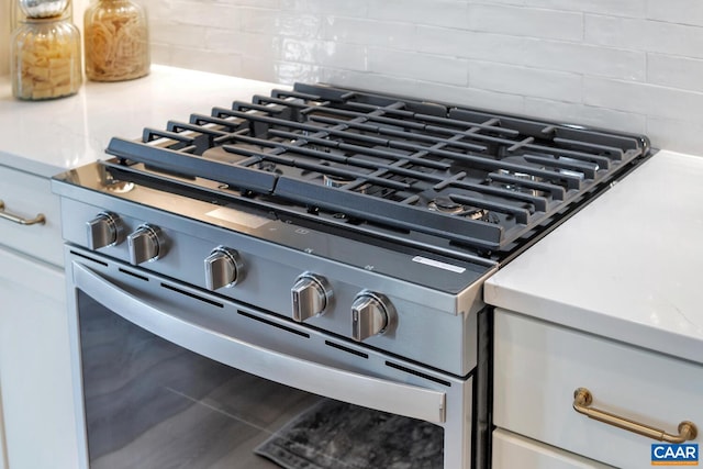 interior details featuring decorative backsplash and stainless steel range