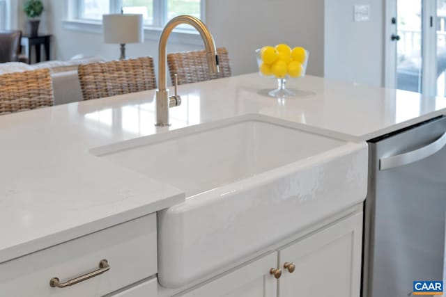 room details with dishwasher, light stone countertops, sink, and white cabinetry