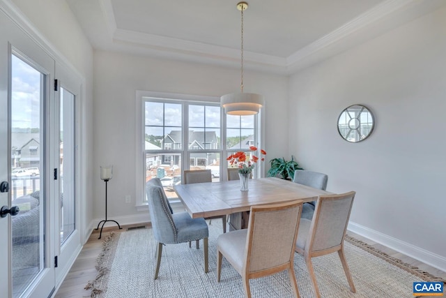 dining room with a raised ceiling and light hardwood / wood-style flooring