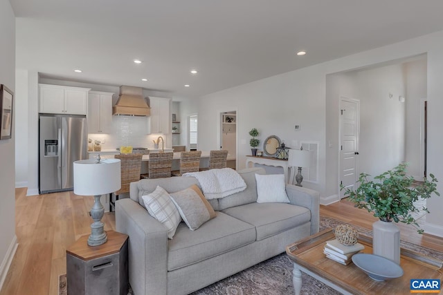 living room featuring light hardwood / wood-style flooring and sink