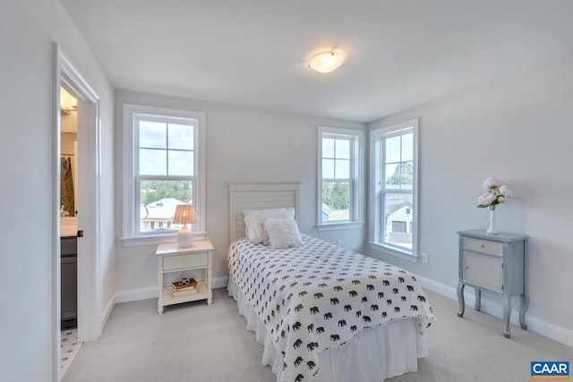 bedroom with ensuite bath and light colored carpet