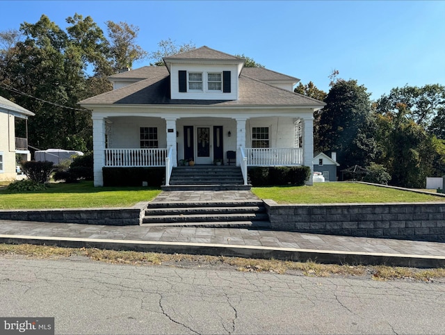 bungalow-style home with a front yard and covered porch